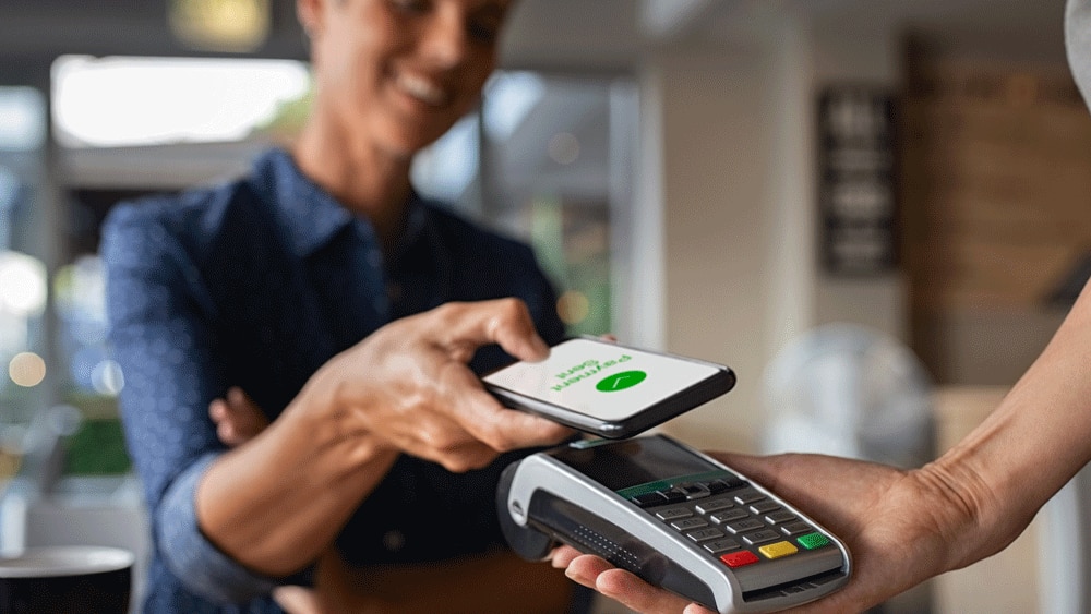 Person paying for purchase via contactless mobile phone payment