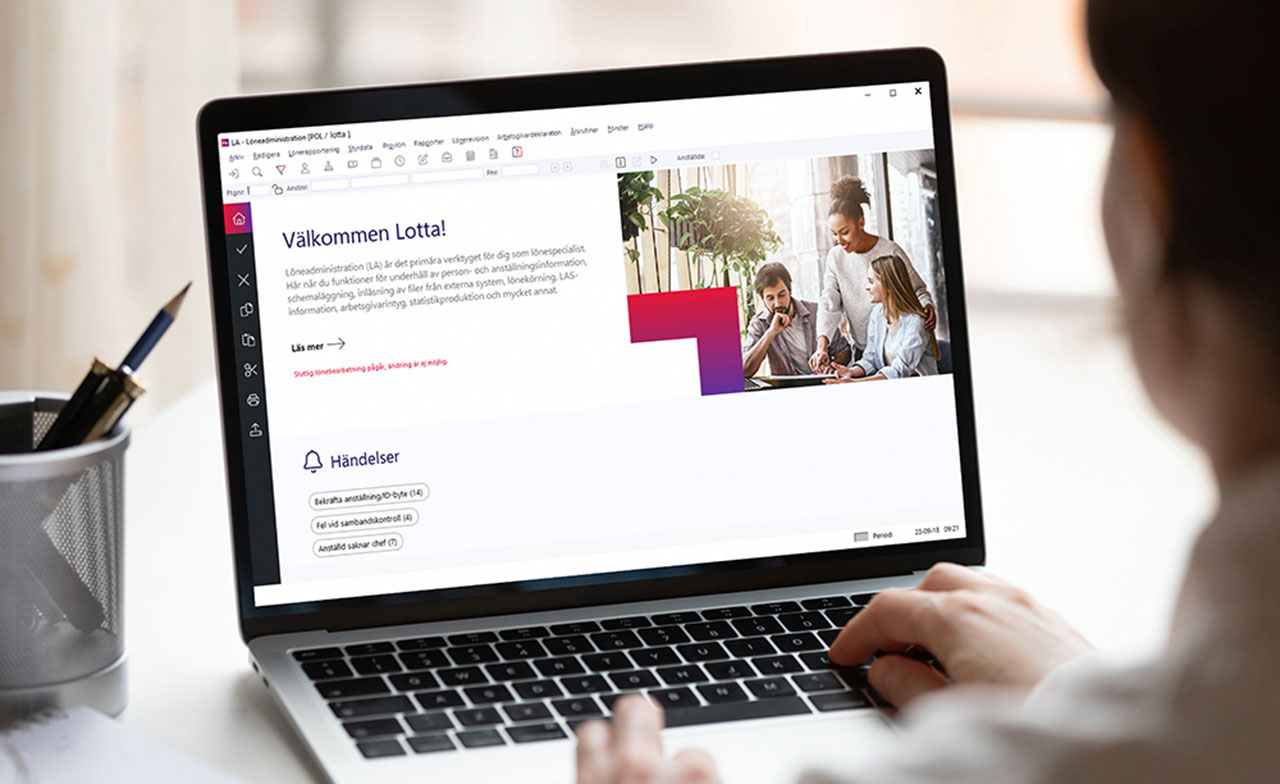 person_using_digital_business_platform_on_laptop En person sitter vid ett skrivbord och använder en laptop som visar en digital webbtjänst med text, bilder och navigeringsalternativ.