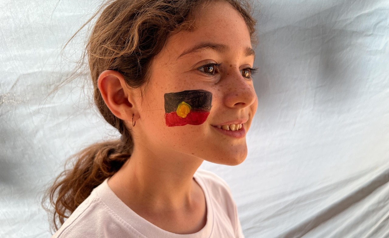 Young person with aboriginal flag painted Young person with aboriginal flag painted