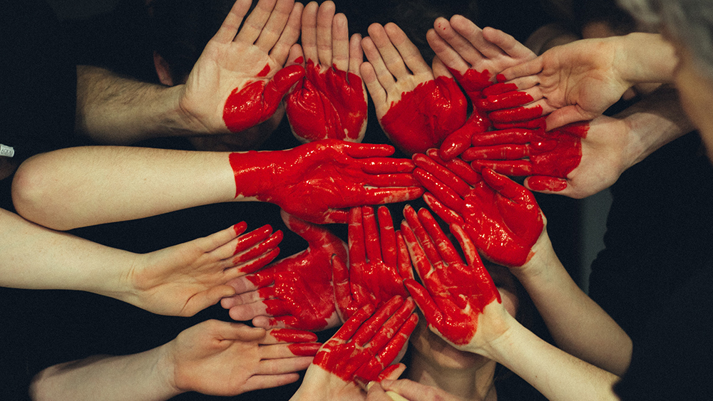 En grupp händer som målats med rött hjärta.