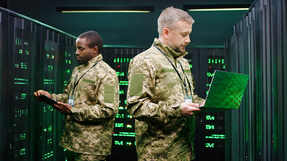Två militärklädda män i ett datacenter