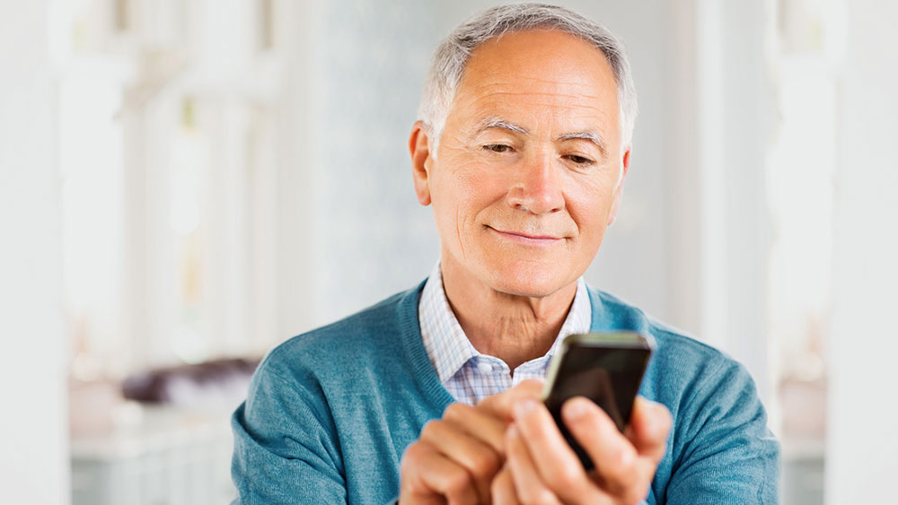 Eläkkeelle jäävä mies käyttää älypuhelinta