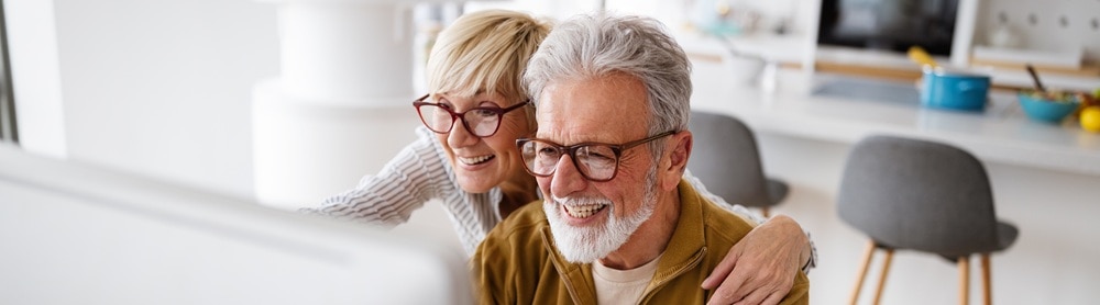 Un couple de seniors utilisant leur ordinateur à domicile