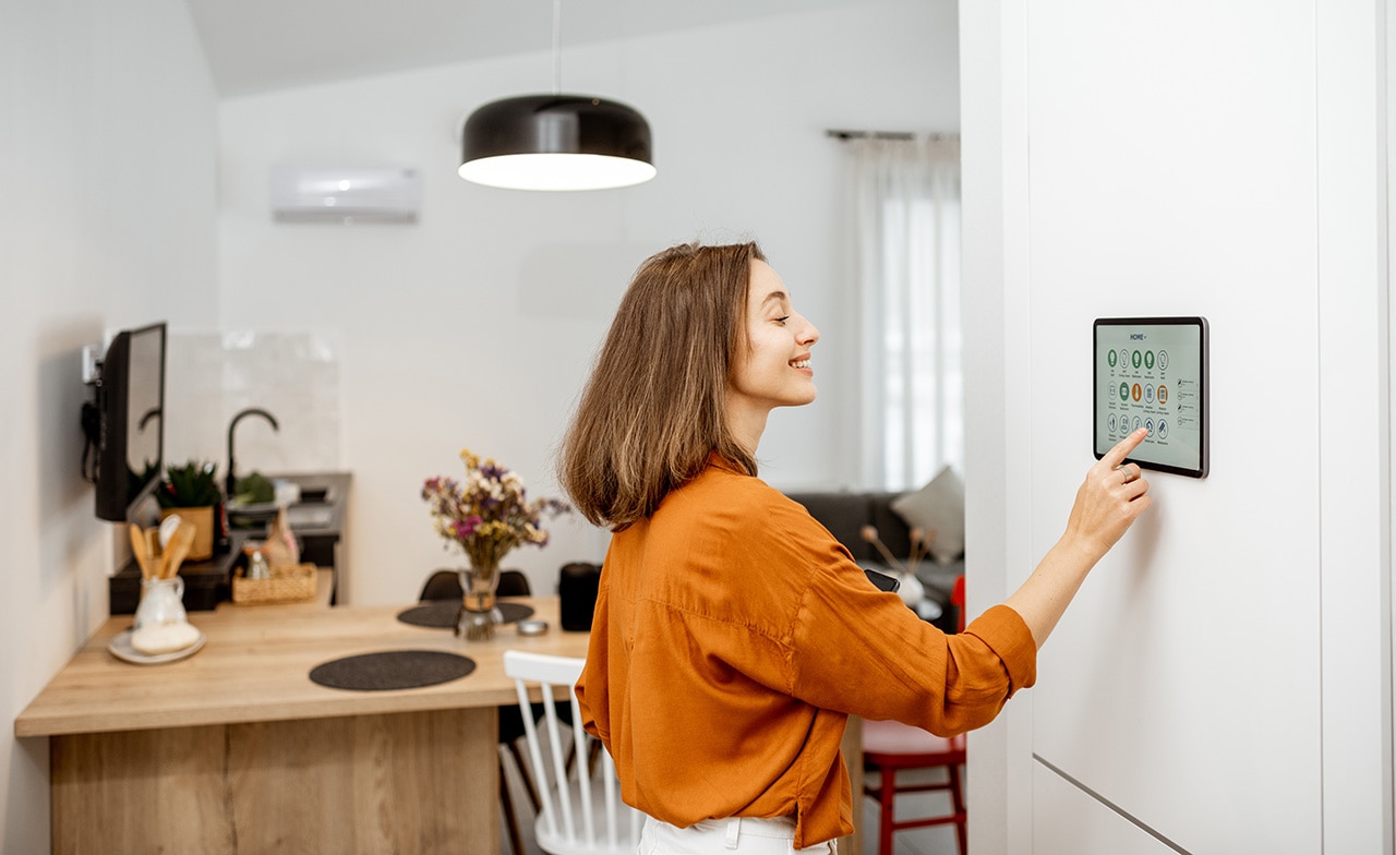Henkilö hallitsee älykotia tabletin kautta