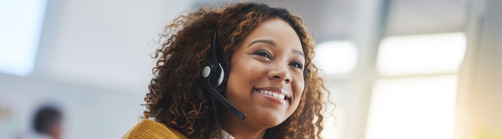 smiling-business-person-talking-headset-mobile-600690322 Smiling business woman talking on a headset