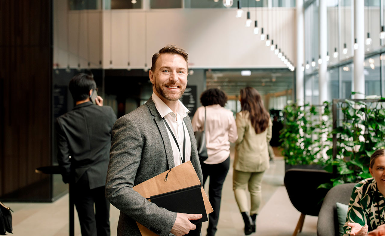 businessman_smiling_in_modern_office_lobby
