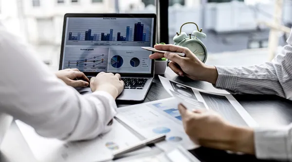 two colleagues looking at data on a computer screen