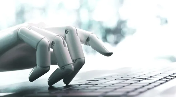 Robot hand on computer keyboard