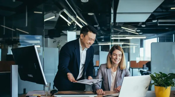 two coworkers looking at computer screen