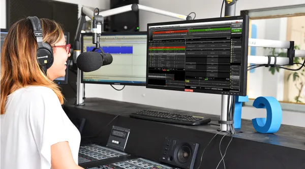 Professional speaking into microphone using dira OnAir Player in studio