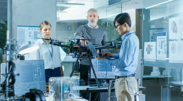Engineers work with new drone in a lab setting