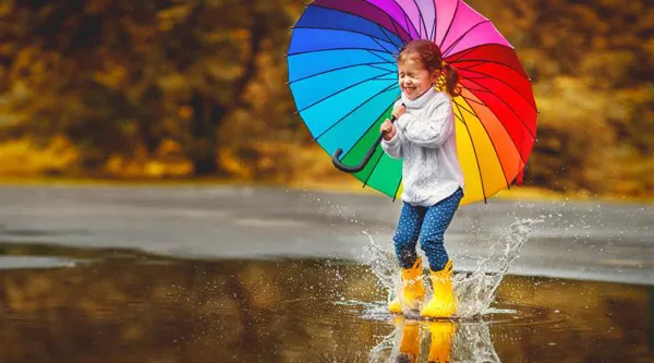 Kleines Mädchen mit einem bunten Regenschirm