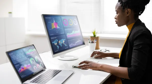 Femme analysant des donnees sur ecrans pour visualisation et analyse de donnees