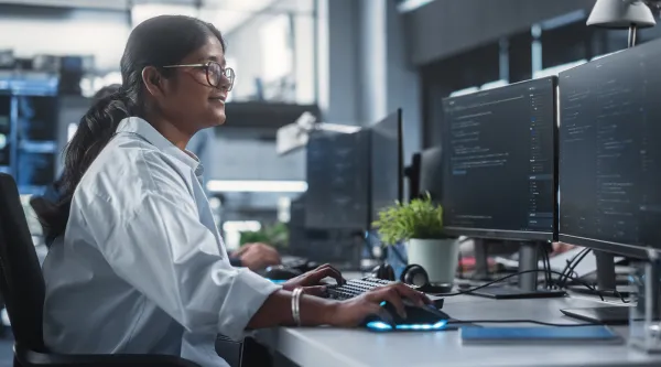 Woman working on multiple screens