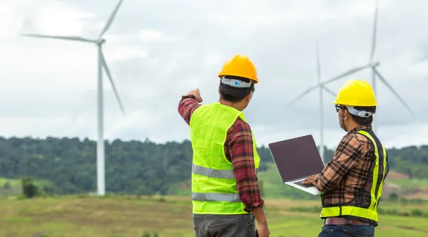 Renewable energy workers reviewing wind farm