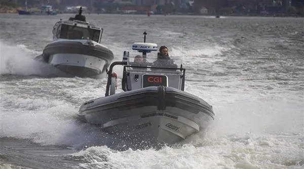 A rigid inflatable boat with a “CGI” logo on the console speeds through choppy water