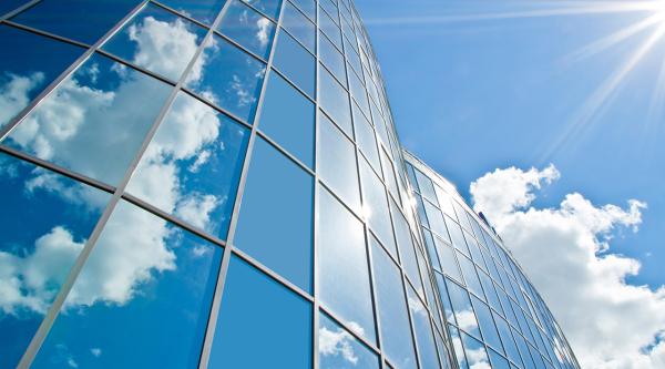 Wolkenhimmel spiegelt sich in einem Glasgebäude