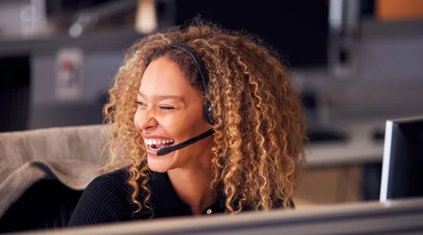 smiling female contact centre employee wearing a headset