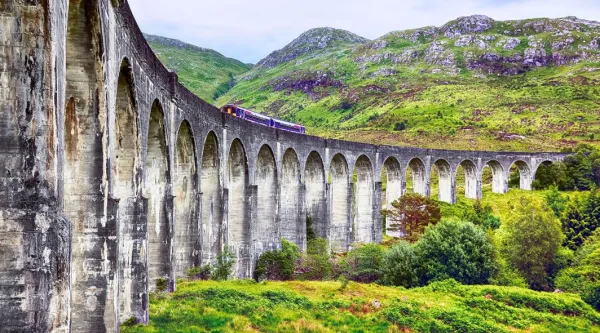 Train moving across the Glenfinnan viaduct in the Scottish Highlands