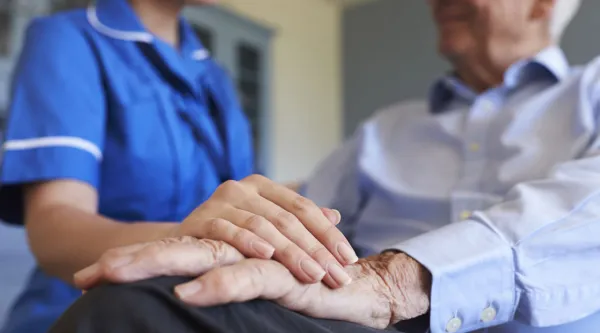 nurse placing hand on patients hand