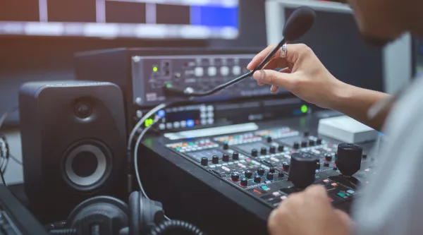 Professional in front of broadcast control panel