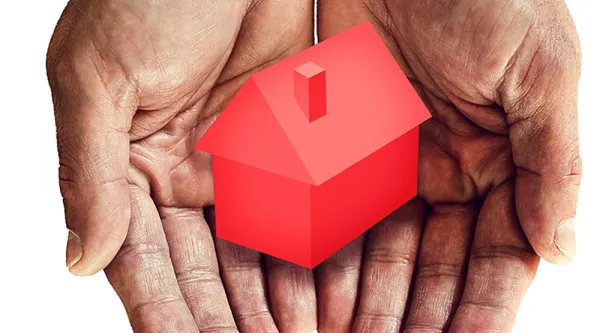 caring hands holding house model