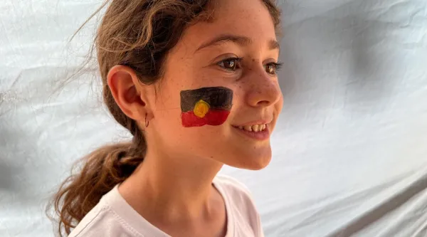 Young person with aboriginal flag painted 
