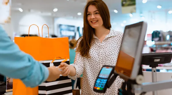 shopper paying for goods at retail counter point of sale (POS)
