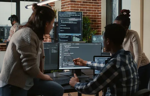 team working at a computer looking at code