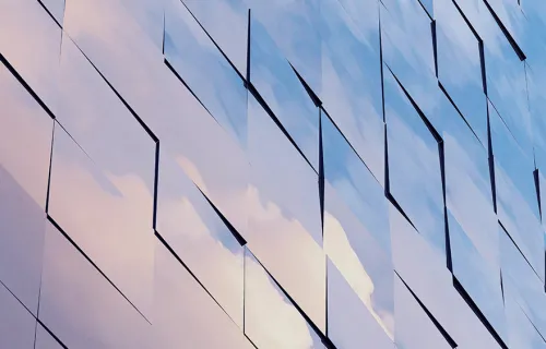Kuvituskuvassa lasiseinä, jonka moduuleihin heijastaa pilvet taivaalta