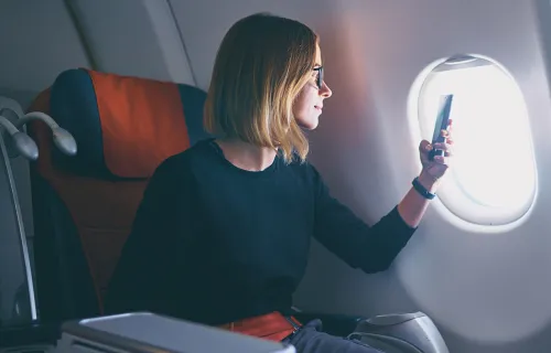 Reisende bruker mobiltelefon til betaling om bord på fly