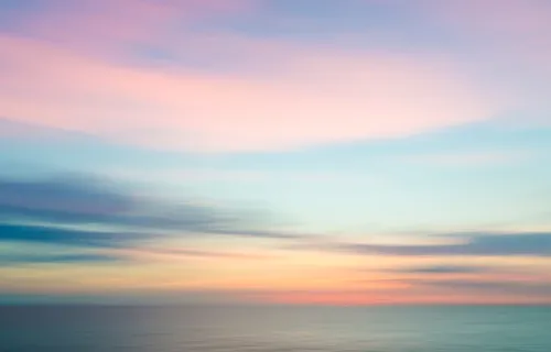 Abstract blurred sky at sunset with blue ocean background
