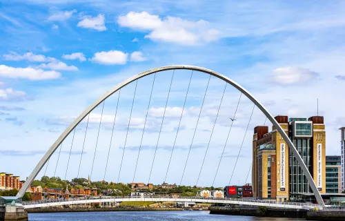 The Gateshead Millennium Bridge, a large white arch pedestrian and cycle bridge spanning the…