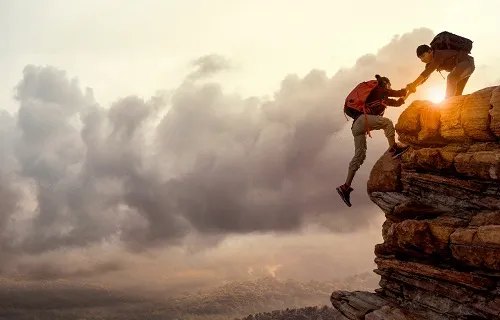 Zwei Bergsteiger helfen sich gegenseitig einen Berg zu erklimmen