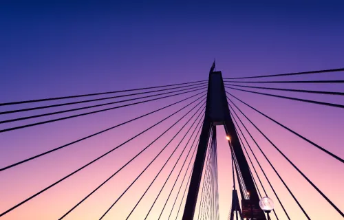 Kuvituskuvassa sillan siluetti iltataivasta vasten