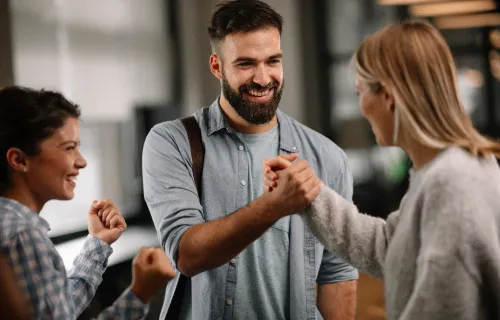 A man and a woman clasping hands in a friendly handshake