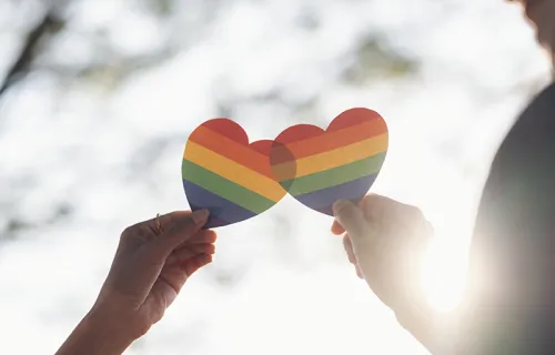 Couple holding rainbow heart