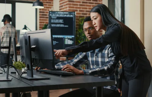 Deux personnes discutent l'informatique quantique face à un ordinateur