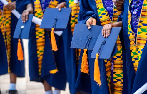 A group of graduates wearing navy blue caps and gowns