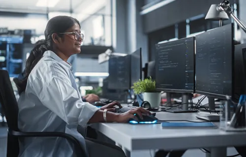 Young Female Artificial Intelligence Engineer Working on Computer in a Technological Office.