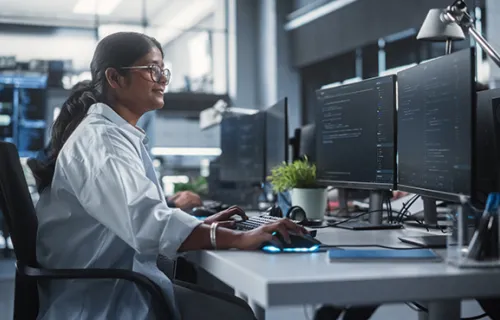 Young Female Artificial Intelligence Engineer Working on Computer in a Technological Office.
