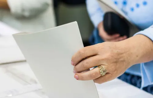 Voter puts paper vote in ballot box