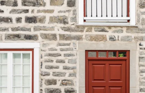 Brick wall with red door and windows