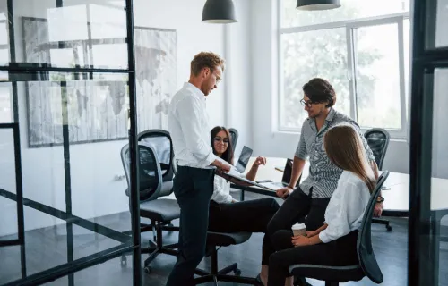 Business strategy consultants around table looking at laptop together