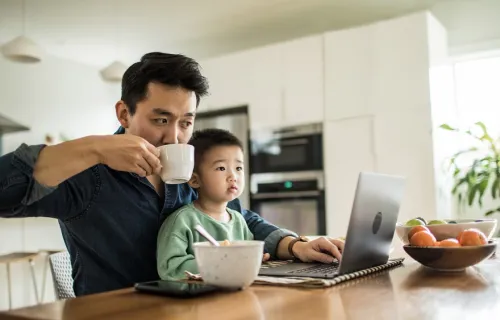 father looks at computer screen with son preventing collections during hardship times 