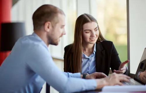 CGI Sustainability consultants look at laptop together