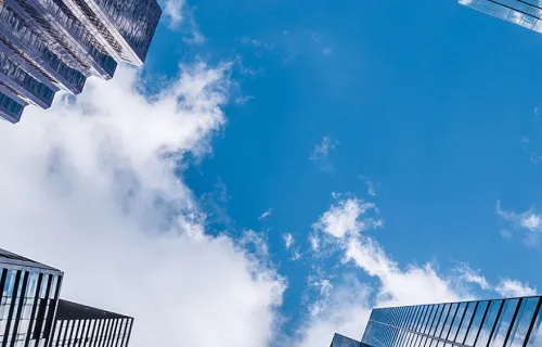 Street view of clouds above high-rising buildings in a city