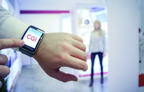 Une personne montre le logo CGI sur sa montre connectée