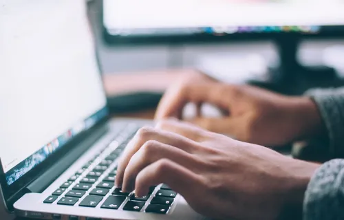 Händer som skriver på en laptop
