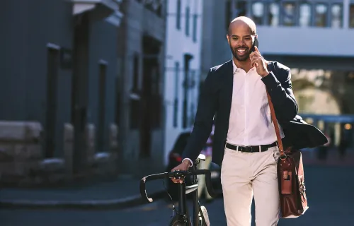 Consultant on cell phone walking to office beside bicycle